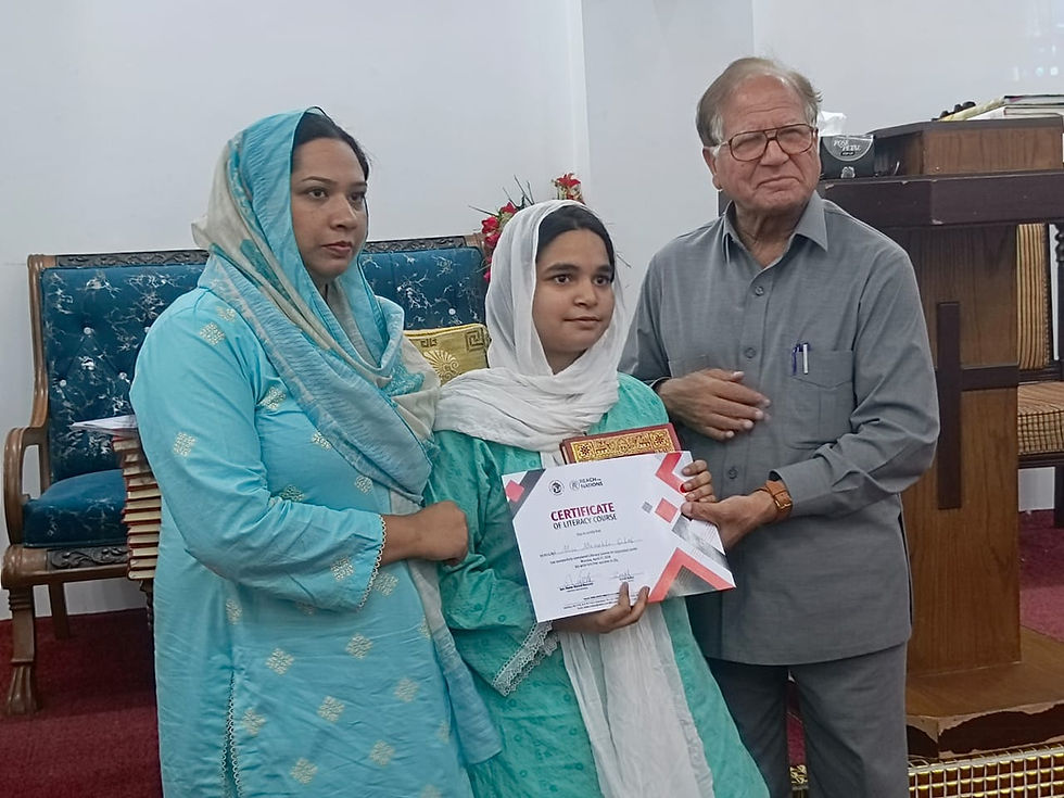 This young graduate receives her certificate and Bible from Manzoor and Zarish.