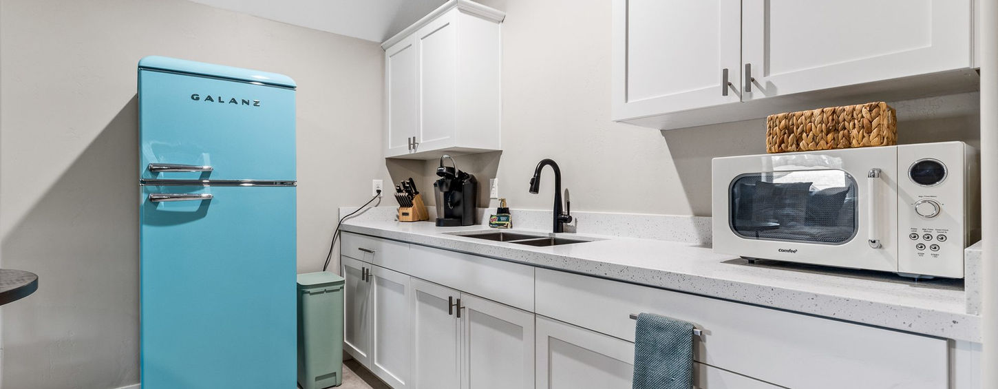Bonus suite kitchenette with retro turquoise refrigerator, microwave and white cabinets