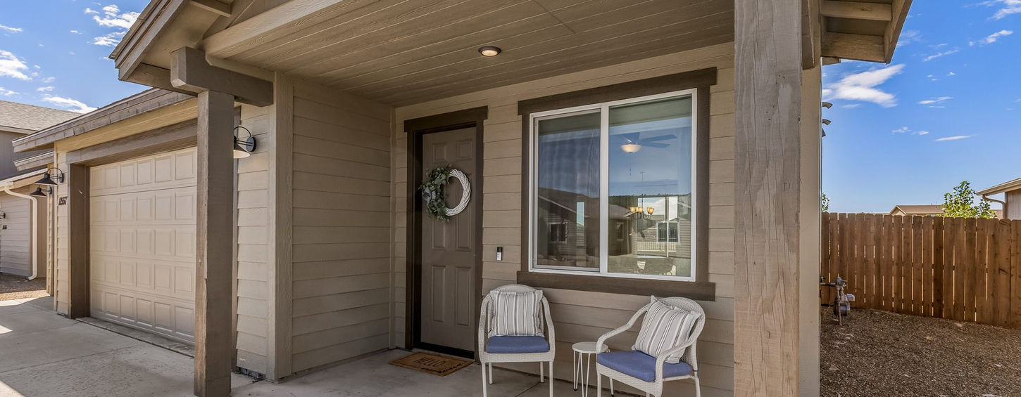 Covered front porch with two chairs by the front door