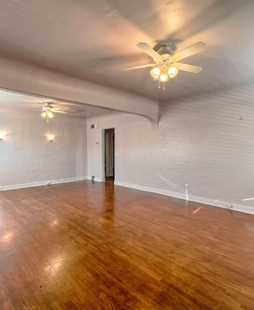 Light‑filled living and dining area inside the bungalow at 20 E Cherry Ave with warm hardwood floors, neutral walls, a large double‑pane window and a cozy seating arrangement; the open layout flows toward adjoining rooms and highlights the home’s natural ligh