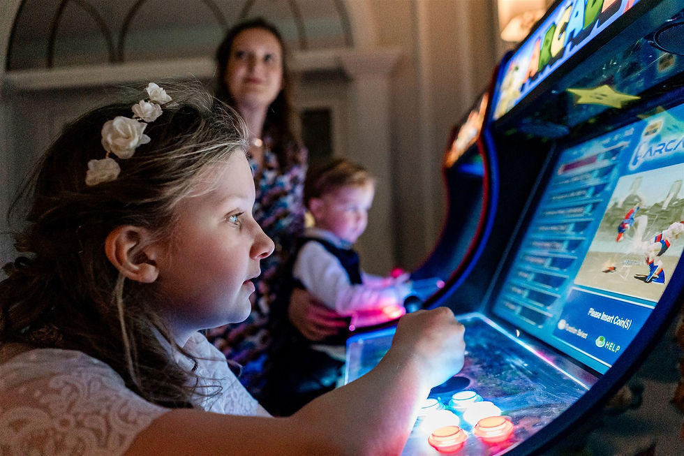 a girl playing arcade games at a wedding in tullyglass house hotel