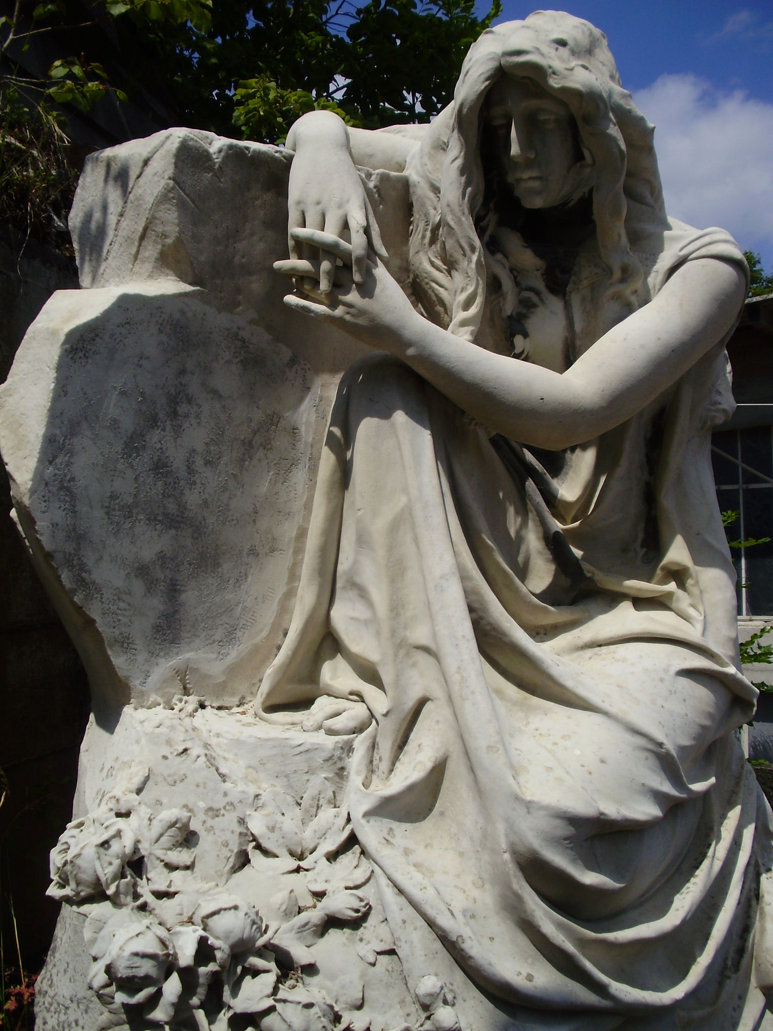 Frau an Mauer angelehnt