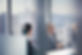 Business professionals in discussion during a meeting in a modern office with large windows