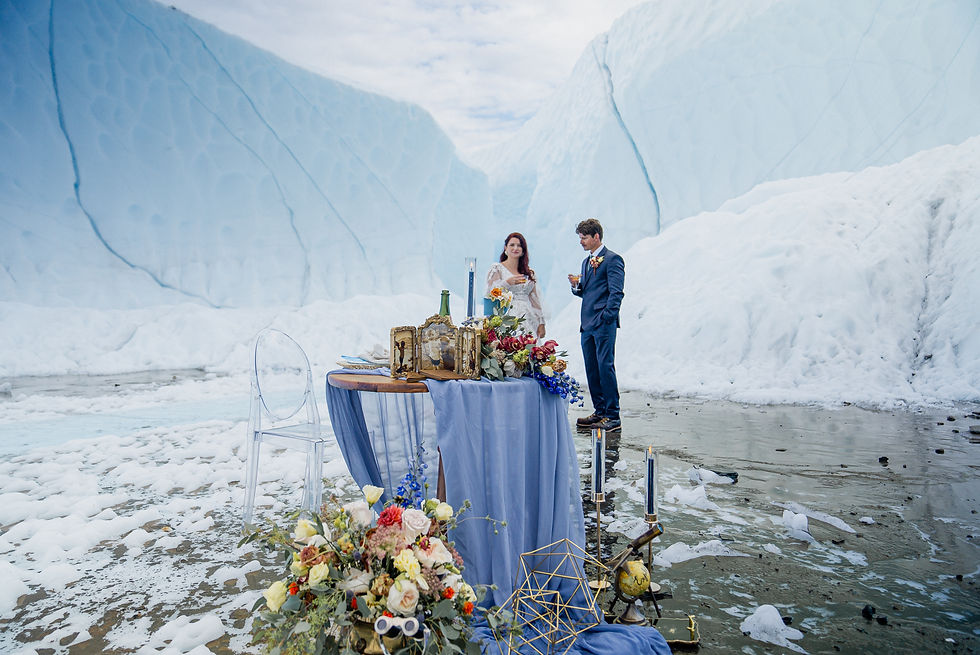 Ghost chairs and vintage wood table with touches of blue and burnt orange is the perfect decor for this Alaska elopement