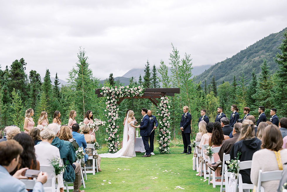 Alaska mountain wedding ceremony with pink florals. Moose Pass, Alaska mountain backdrop at Inn at Tern Lake. Best Alaska venue ideas with wedding planning services.