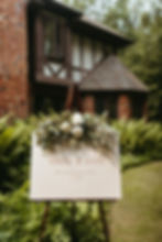 Beautiful, simple wedding signage with garland and flowers