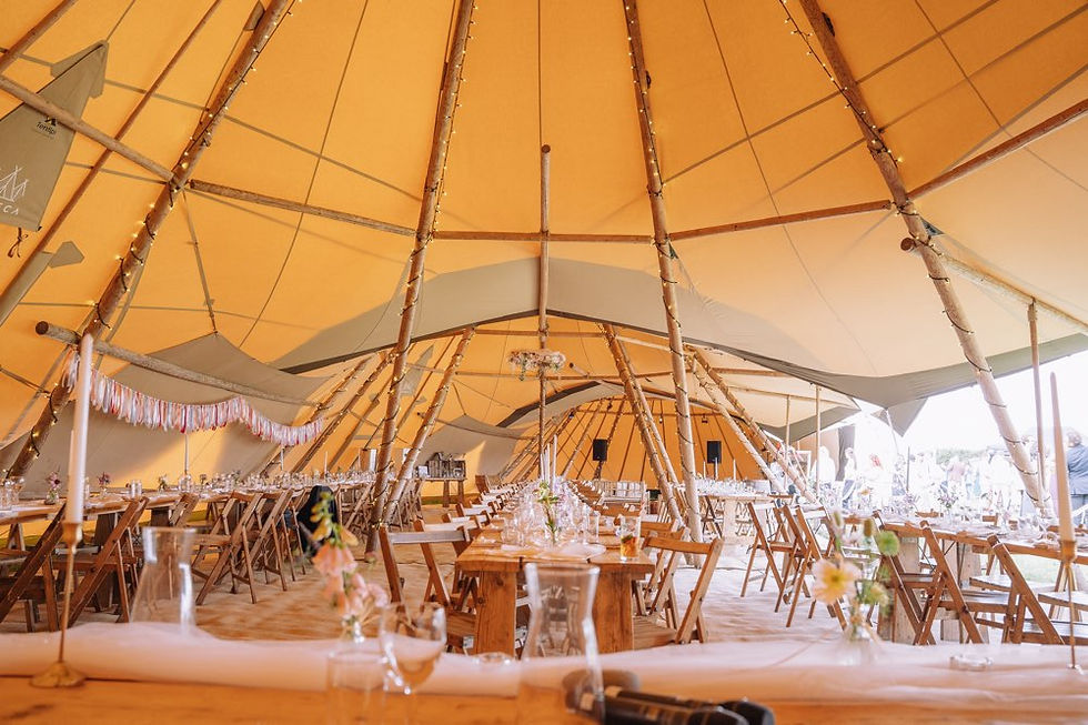 Giant tipi with tables and chairs decorated for a wedding
