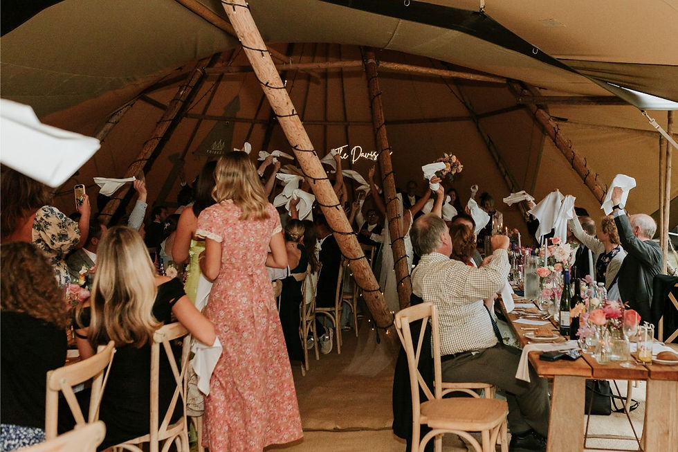 Guests at tables at tipi wedding reception