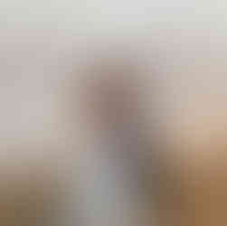 Festival wedding with bride and groom and guests around a firepit in a field