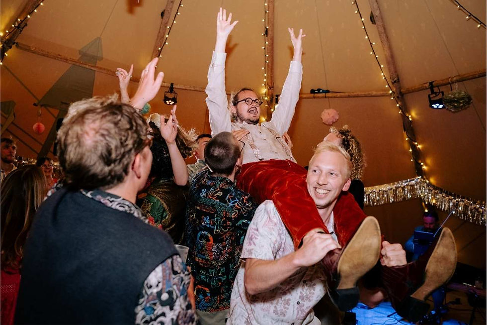 Groom on dancefloor with friends at tipi wedding