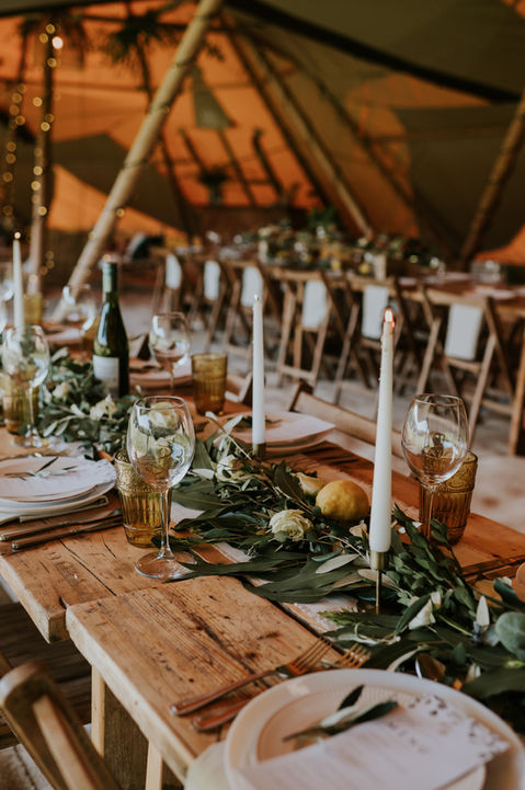 Rustic wedding table settings with flower garlands and candles