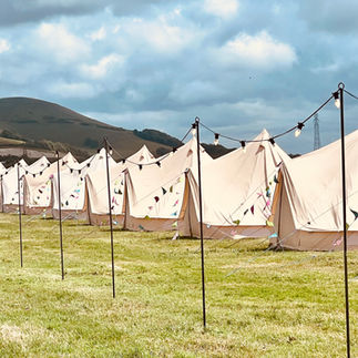 Bell tents in a field with festoon lighting