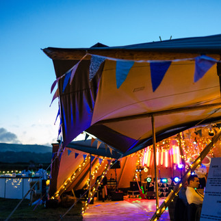 Giant tipis at night with bunting and fairy lights