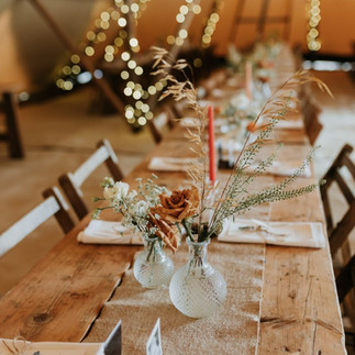 Tipi wedding reception with rustic tables and chairs