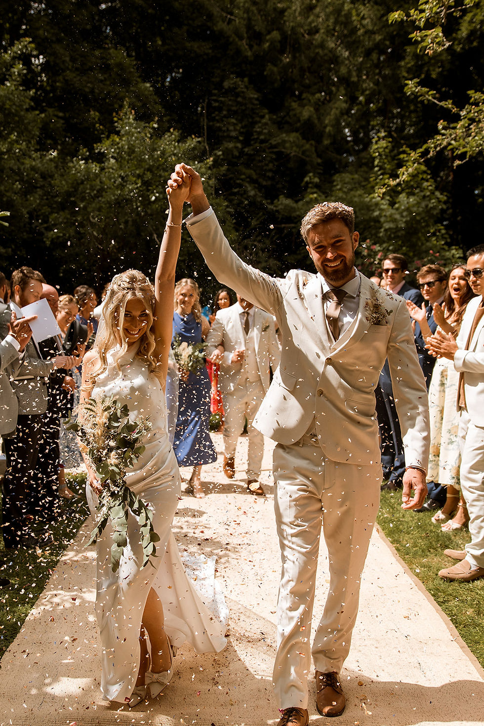 Bride and groom at outdoor garden wedding with confetti shower