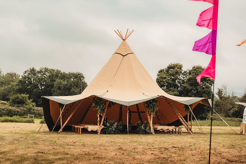 Giant tipi at festival wedding with colourful festival flags and botanical floral displays