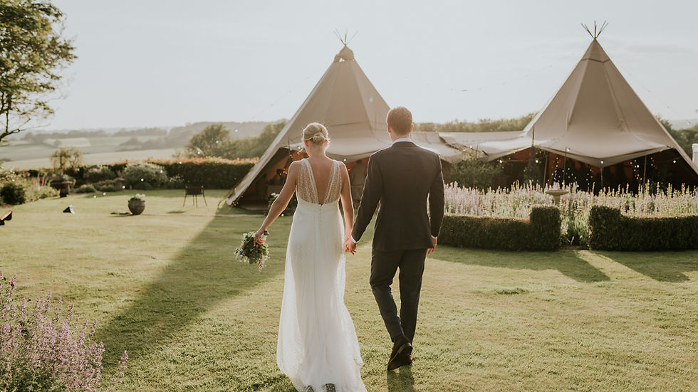 Bride and groom in garden at tipi wedding