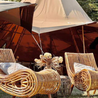 Giant tipis with outdoor furniture in a field
