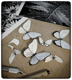 Art in process image of paper butterflies and studio materials