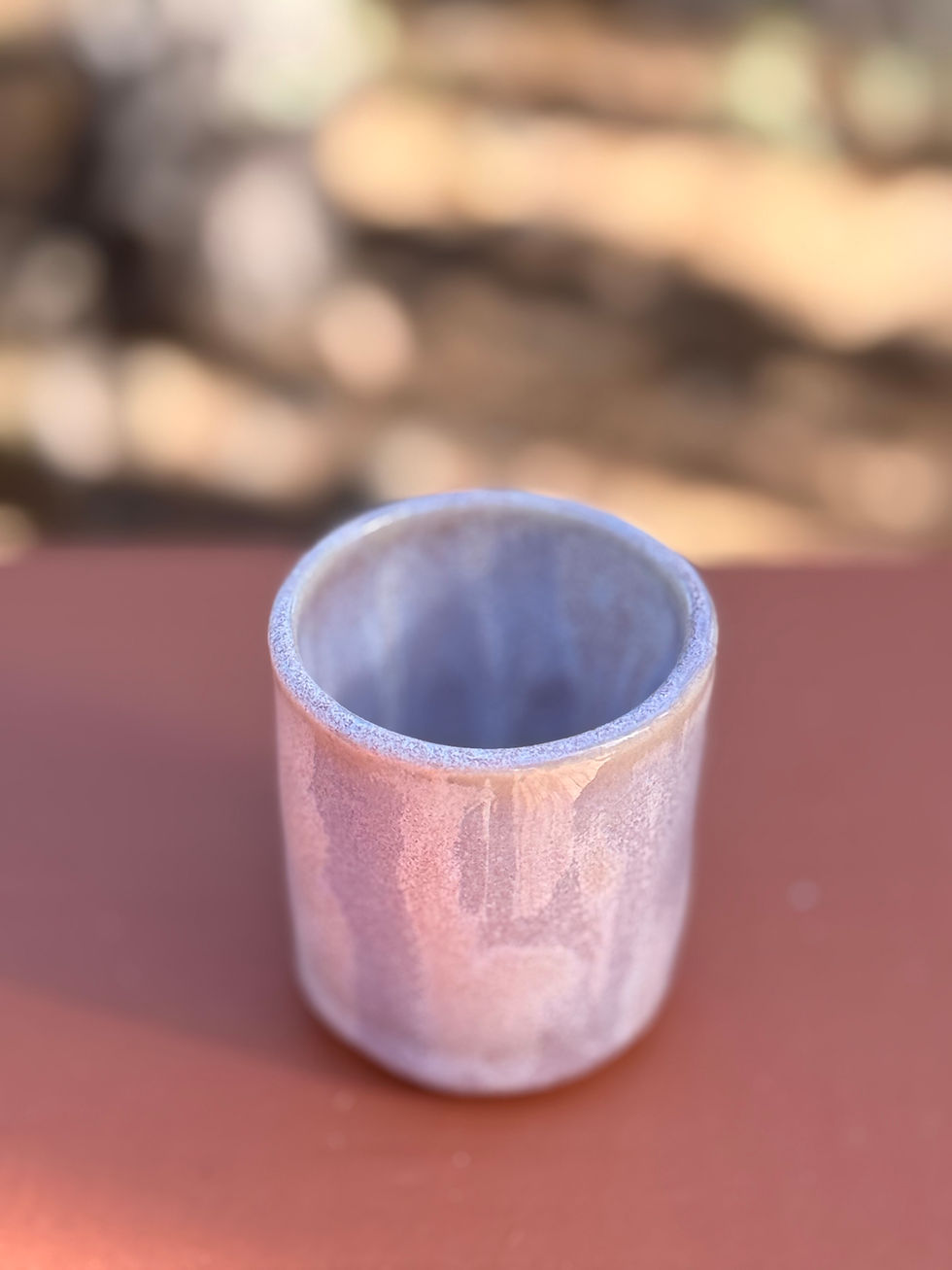 Thumbnail: Handmade mini lavender stoneware cup on a brown surface.