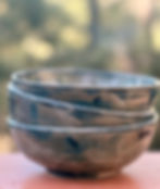 Stacked rustic stoneware serving bowls with mottled glaze