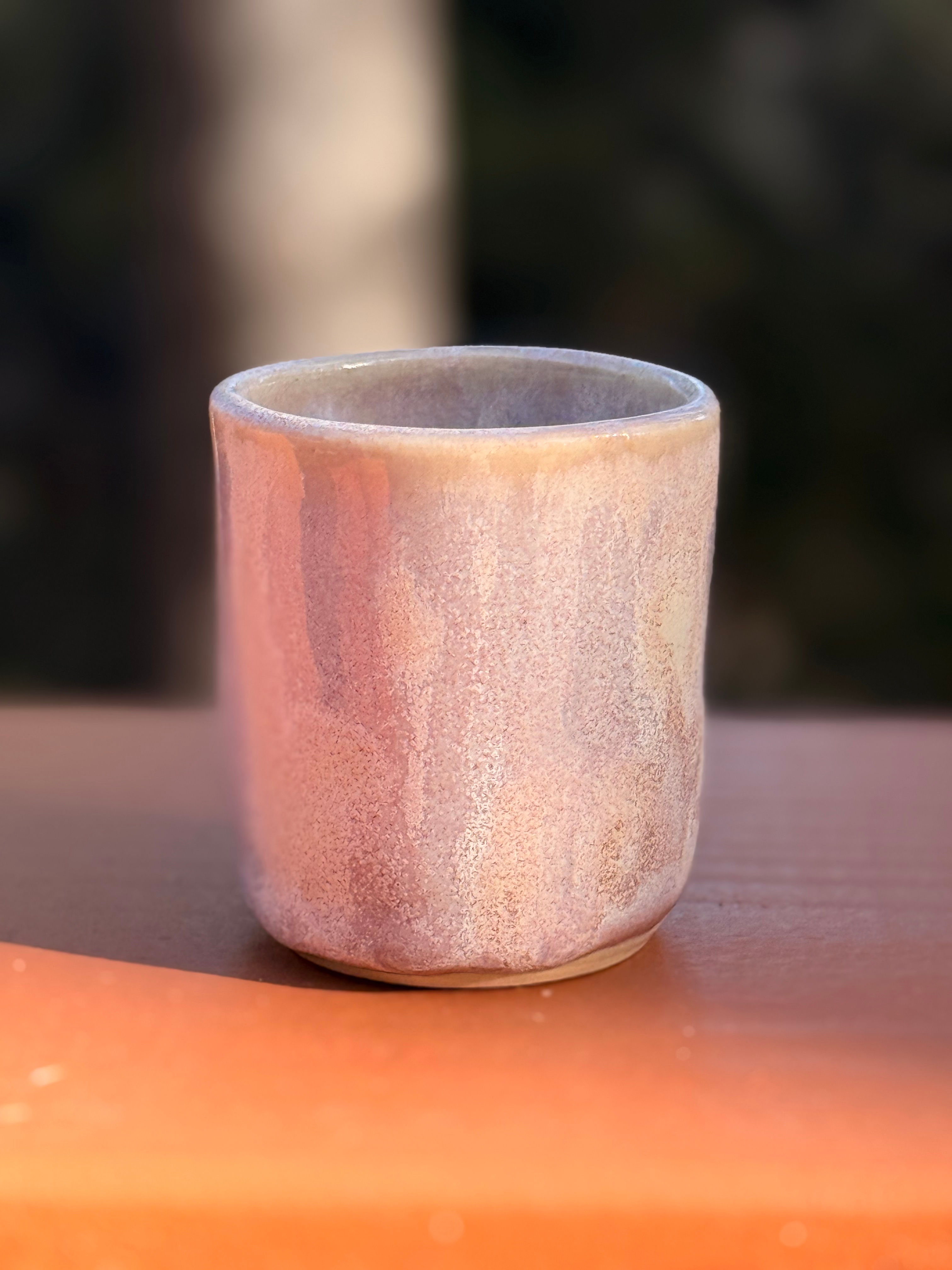 Small lavender stoneware cup with iridescent glaze.