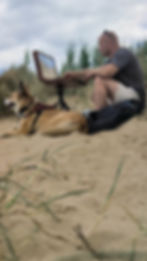 Ben goymour sittin gin the dunes of Brancaster beach painting the sea
