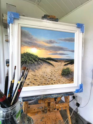 A sun set beachscape  with foot prints through the dunes