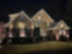 Two-story Wake Forest home outlined with warm-white Christmas roofline lights