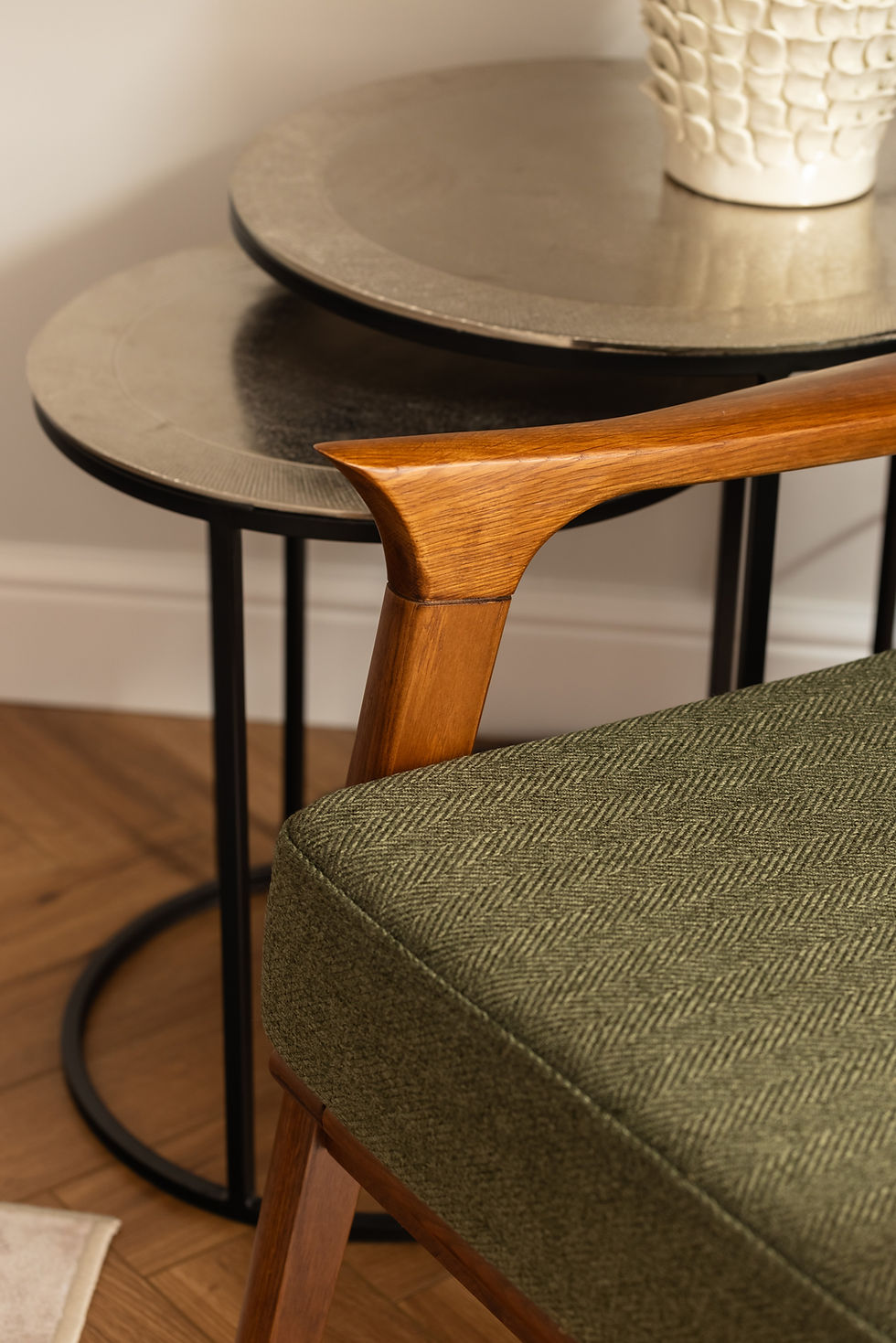 Interior design advice featuring a green armchair and nested tables.