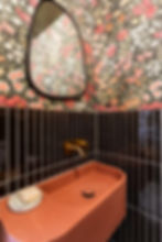 Terracotta sink and floral wallpaper in a modern bathroom