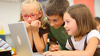 Classroom: three elementary schools students collaborating on a computer