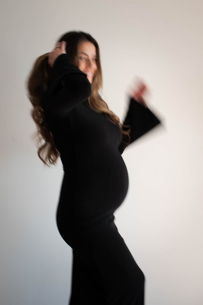 Zwangere vrouw zit op bed. Zwnagerschapsfotoshoot door Maaike van Schothorst fotografie