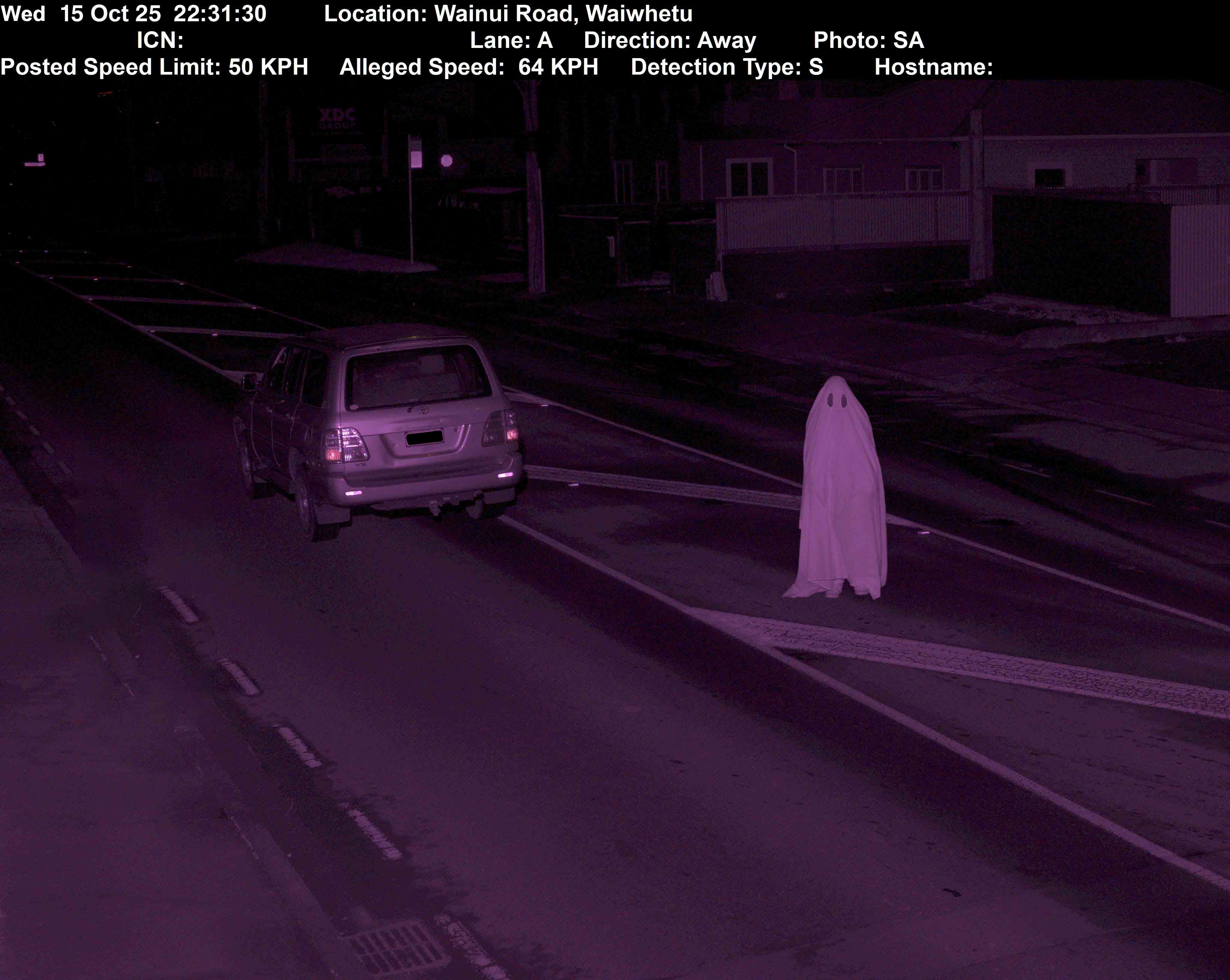 Street intervention by Cameron Hunt featuring a car driving over the speed limit past a ghost figure standing on the road, intentionally triggering a traffic infringement camera to receive and repurpose the official council image as part of the artwork.
