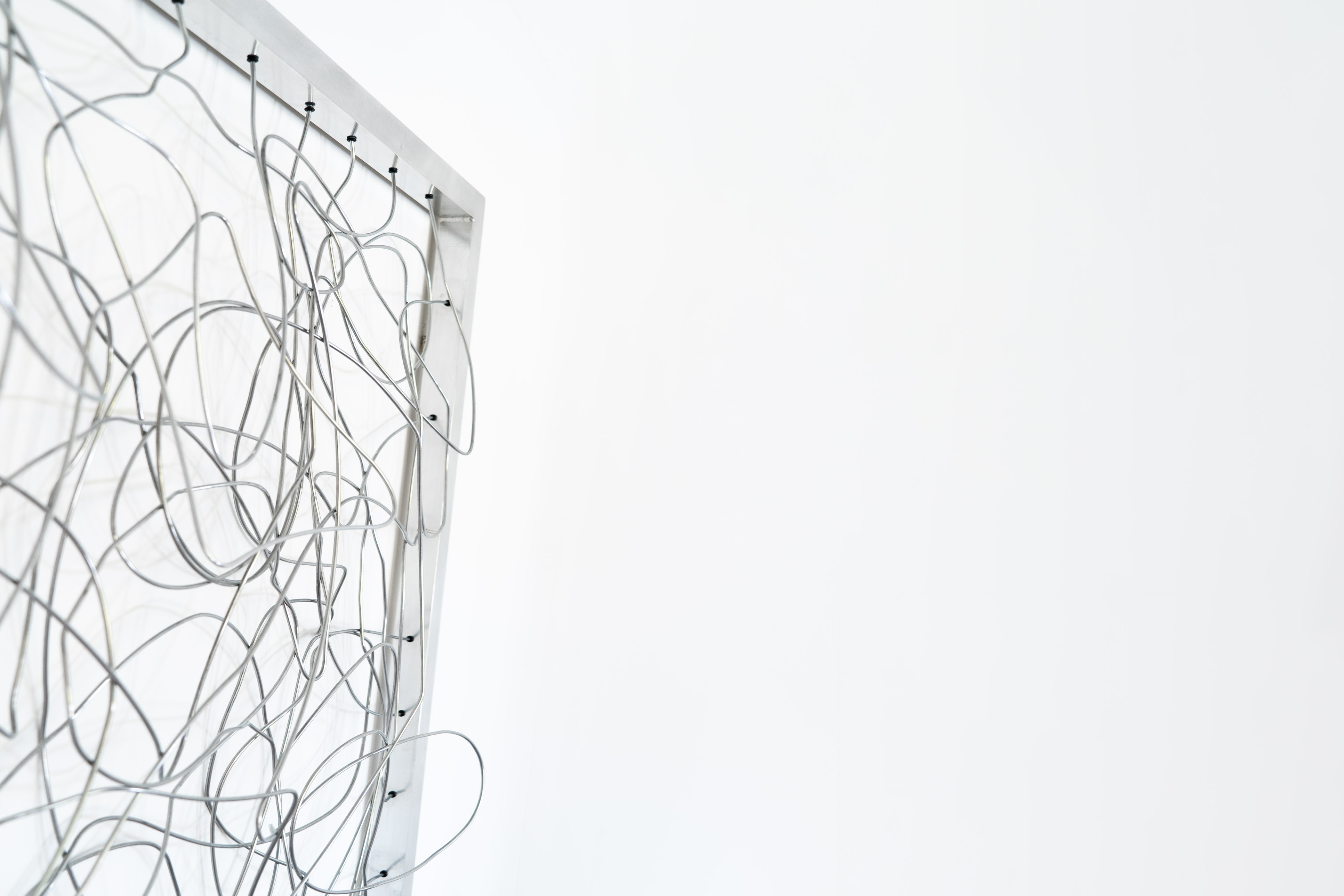 Close-up side view of Cameron Hunt’s wire sculpture showing depth and wire loops extending from the metal frame.