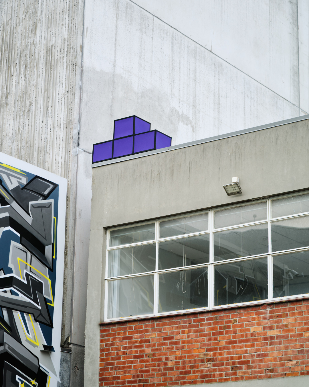 Colourful Tetris cube installation located in the urban environment by street artist Cameron Hunt.