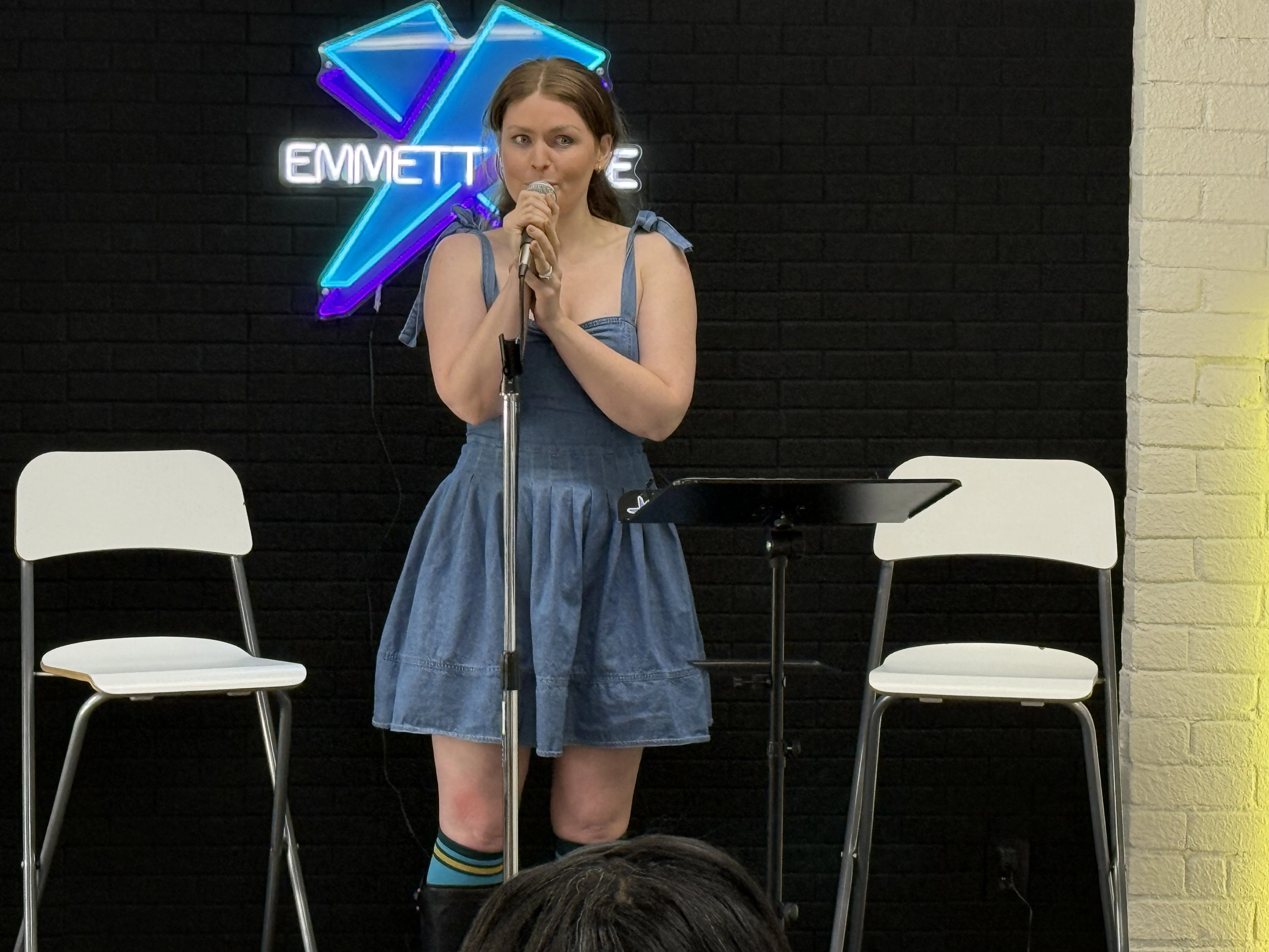 Female student holding a microphone performing a musical theatre song at Emmett Hayes Voice Studio