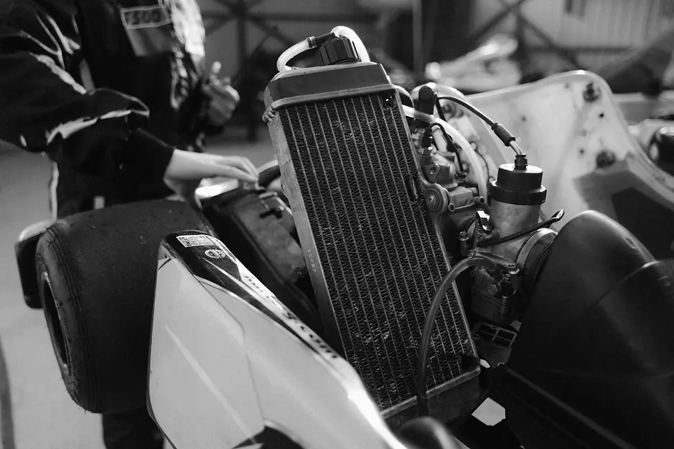 Dettaglio del radiatore e del circuito di raffreddamento di una monoposto da competizione durante la manutenzione in officina