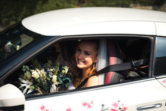 Beautiful young bride smiling through window of white sports car as she arrives at her wedding at the Sun Pavilion Harrogate  