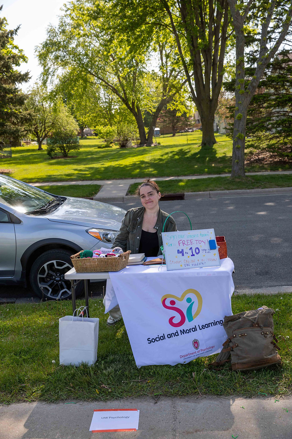 Woman sitting behind table advertising children's studies for UW Psychology