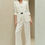 Thumbnail: Woman in an off-white pantsuit