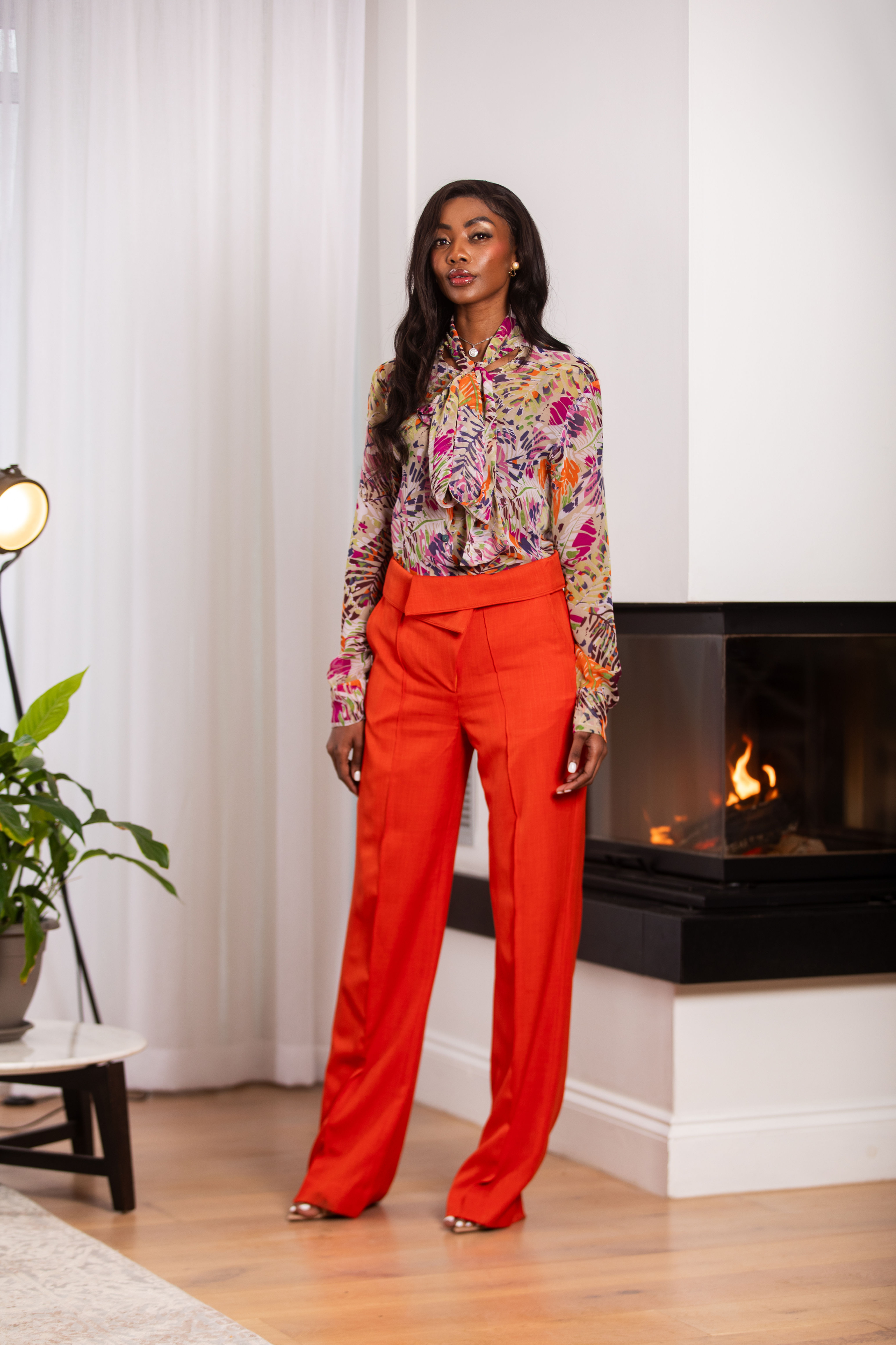Woman in orange pants and floral blouse