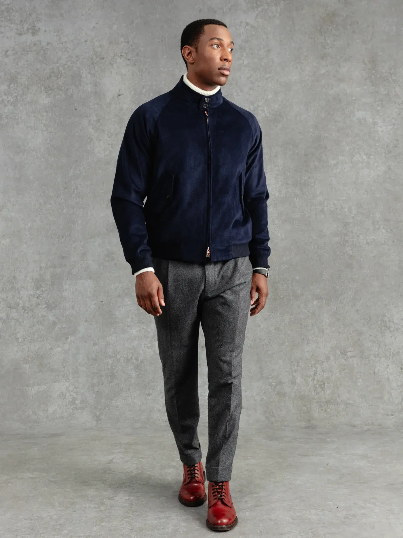 Man modeling navy blue zip-up jacket and gray pants