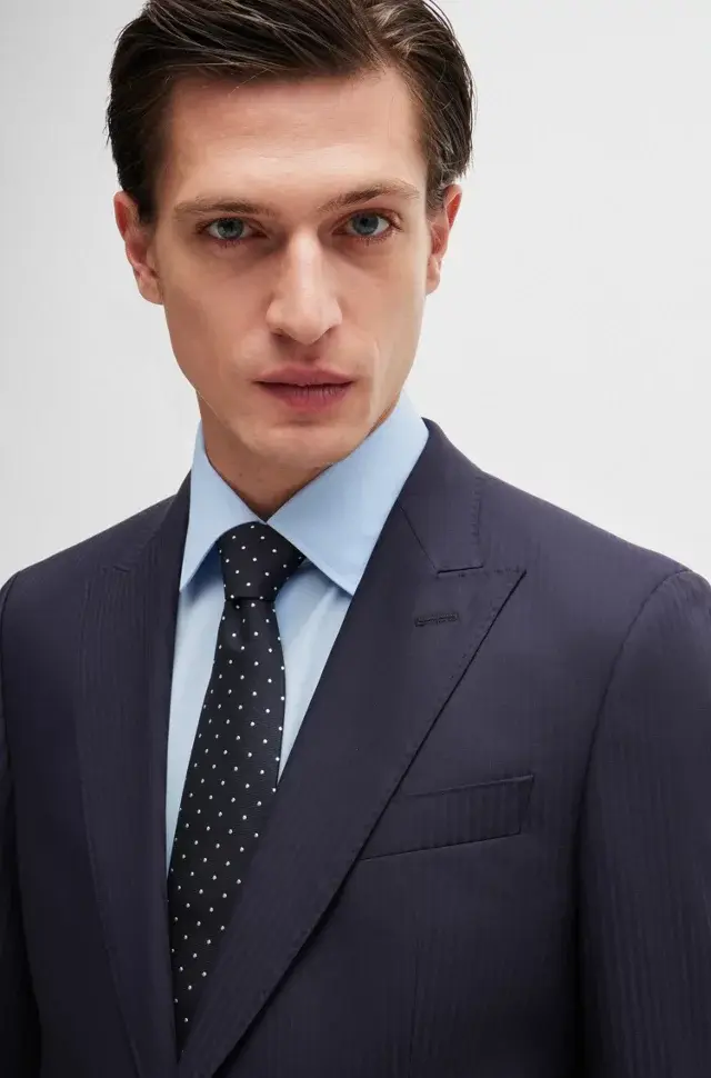 Man in navy suit and light blue shirt