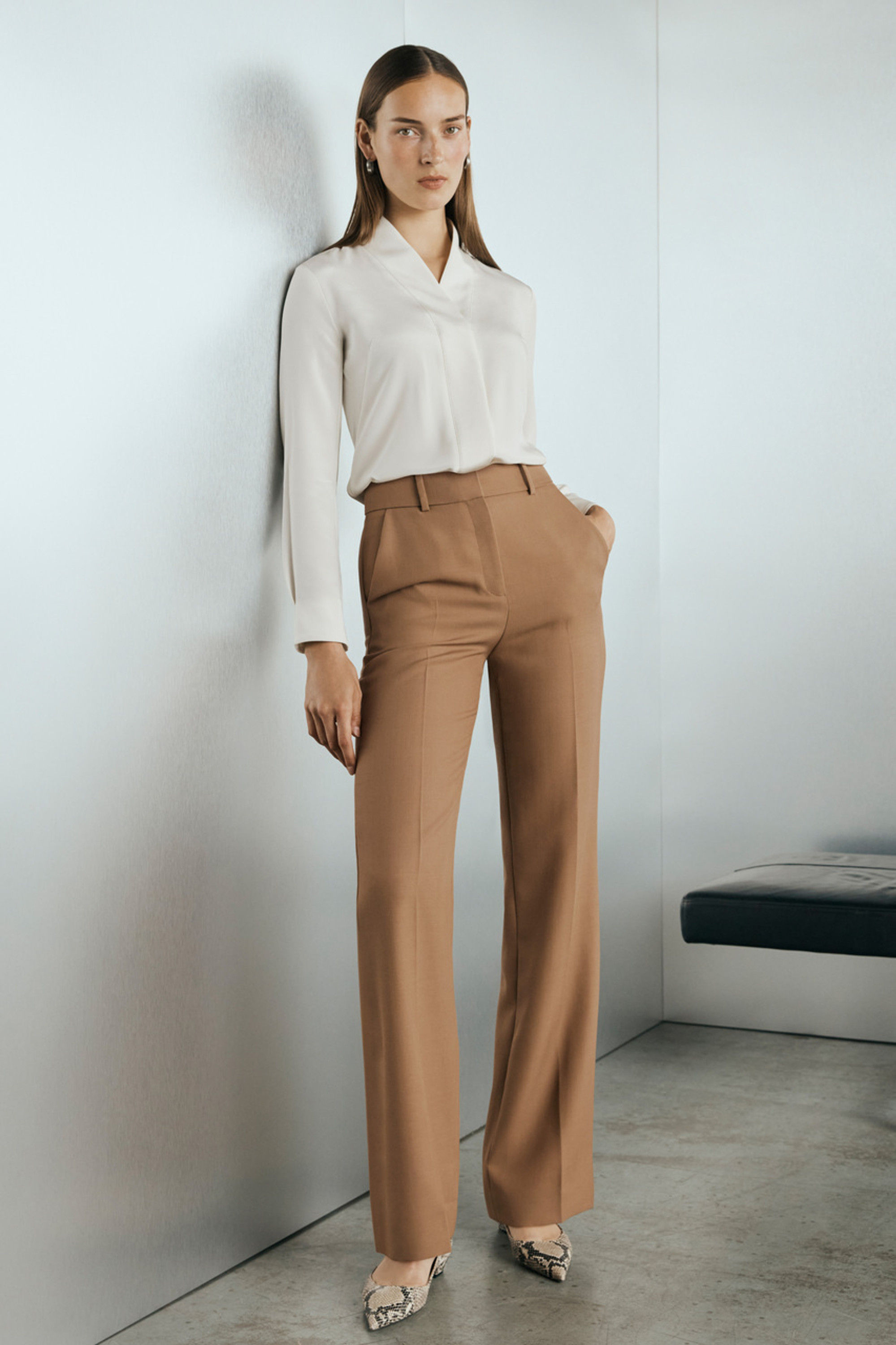 Woman in white shirt and camel pants