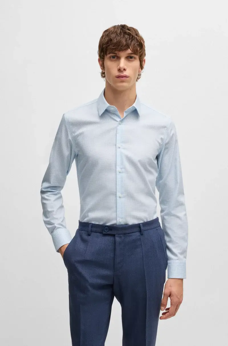 Man in light blue long-sleeve shirt and navy pants