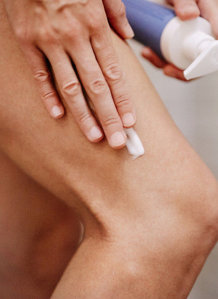 Ein Mensch schmiert das neue Staudigl Naturkosmetik Bodytreatment aufs Bein