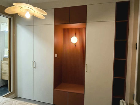 Salon moderne au design minimaliste avec un canapé gris, des coussins colorés et des luminaires design, réalisé par Anka Paris. Anka, l'art de l'intérieur design à Paris.