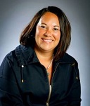 Smiling woman with dark hair in a navy blue jacket.