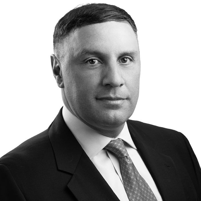 Professional headshot of a team member in a suit.